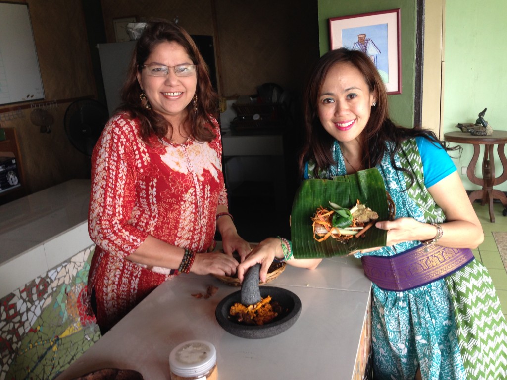 Soulful Balinese Cook Ibu Norra Demonstrating skillful mortar and pestle skills the Indonesian way to co student Eli